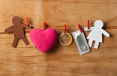 Paper people, a stuffed heart and condoms clothespinned to rope