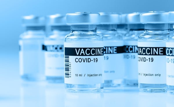 COVID-19 vaccine ampoules with light blue wash over the image