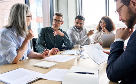 Co-workers at a boardroom table having a discussion