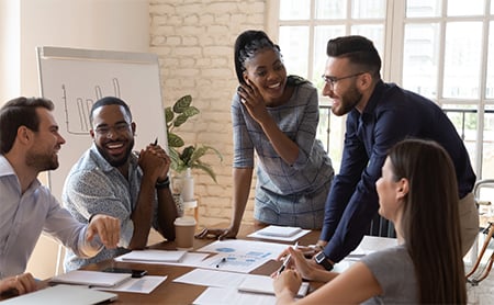 A diverse group of coworkers works collaboratively at a conference table