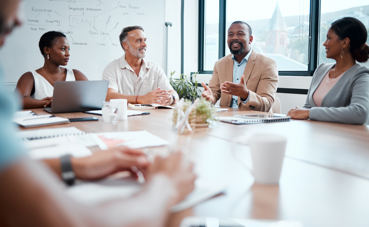 A diverse group of coworkers meets around a conference table