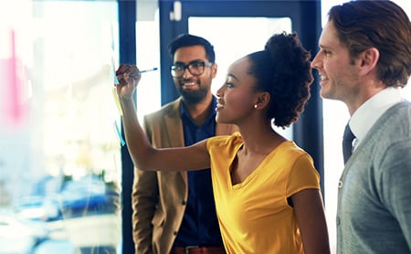 Three coworkers work together during a planning session