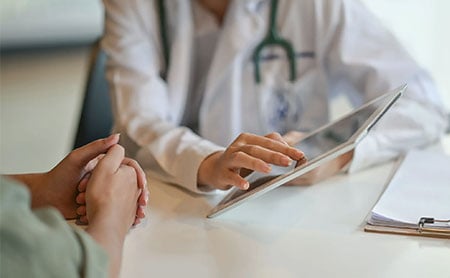 Midsection-crop of doctor showing patient results on a tablet