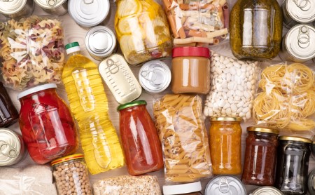 Flay lay photograph of non-perishable foods in bags, bottles, and cans