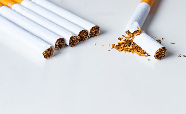 Group of 5 combustible cigarettes with a single broken cigarette out in front