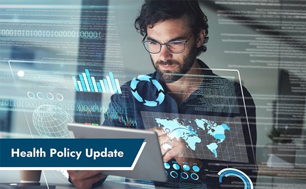 Bearded man in glasses looking at digital charts and graphs on a tablet with Health Policy Update banner.