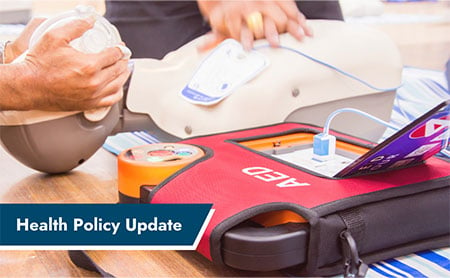 Health Policy Update: two people using an AED machine