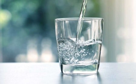 Water pours into a drinking glass