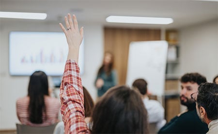 Raised hand in a classroom.