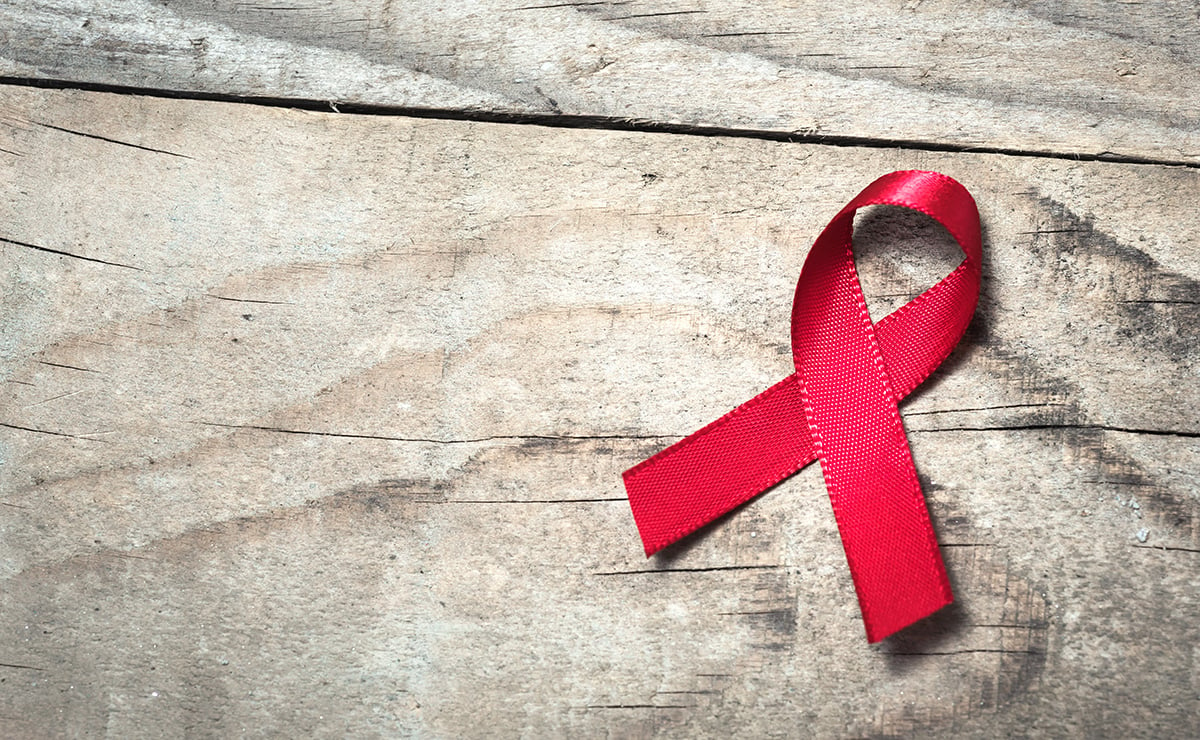 Red AIDS ribbon on a wood table
