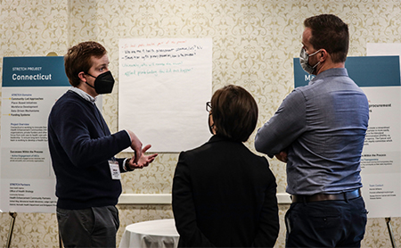 Team members talk during a STRETCH meeting