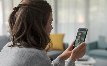 Woman using her cell phone for a telehealth appointment with her doctor